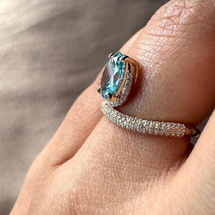 unique pave engagement ring, 1.5ct blue oval, brilliant oval cut, micro pave diamond band, sustainable blue diamond, blue diamond with white halo, teardrop-style oval, sparkling pave setting.