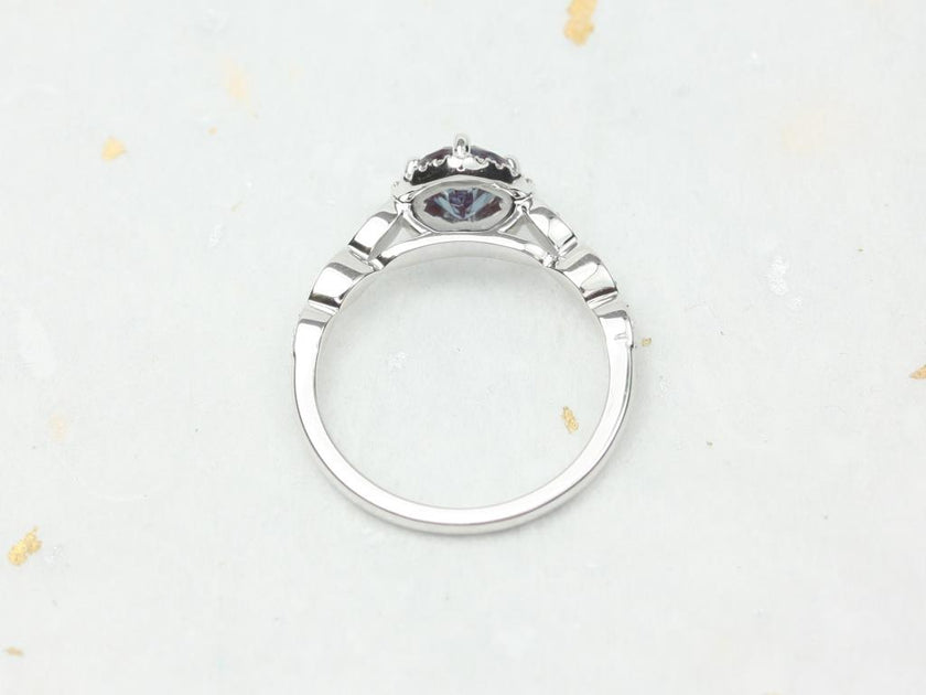 round blue stone halo ring with side diamonds