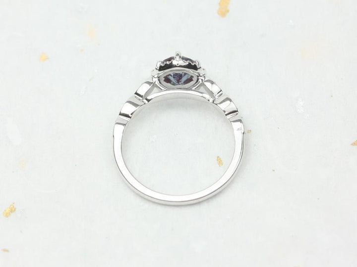 round blue stone halo ring with side diamonds
